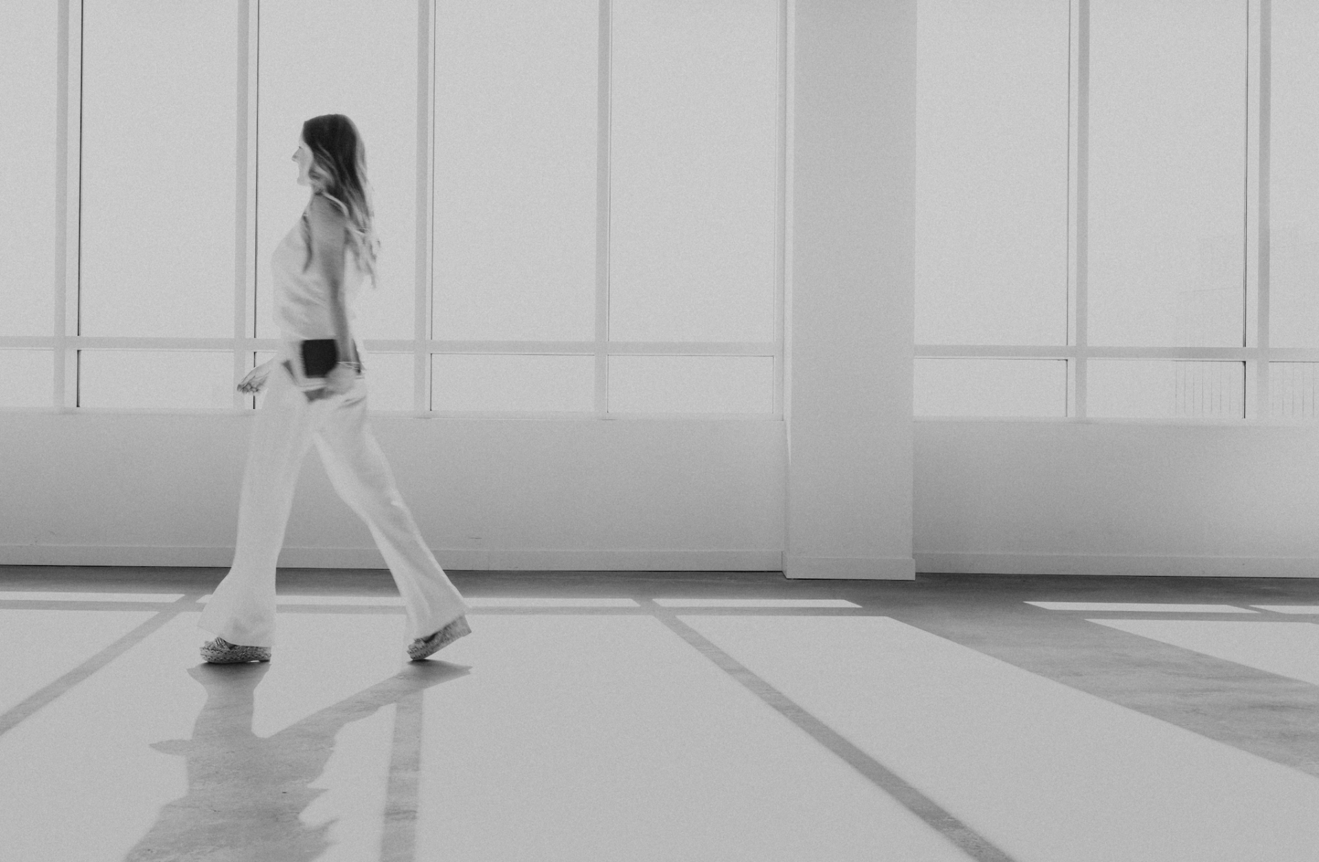 A figure walking through a sunlit space
